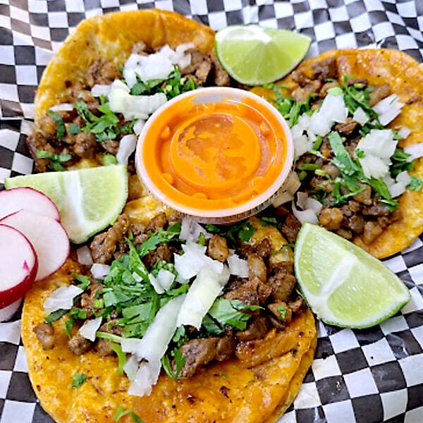 Carne asada tacos topped with fresh onions and cilantro Carne asada tacos topped with fresh onions and cilantro